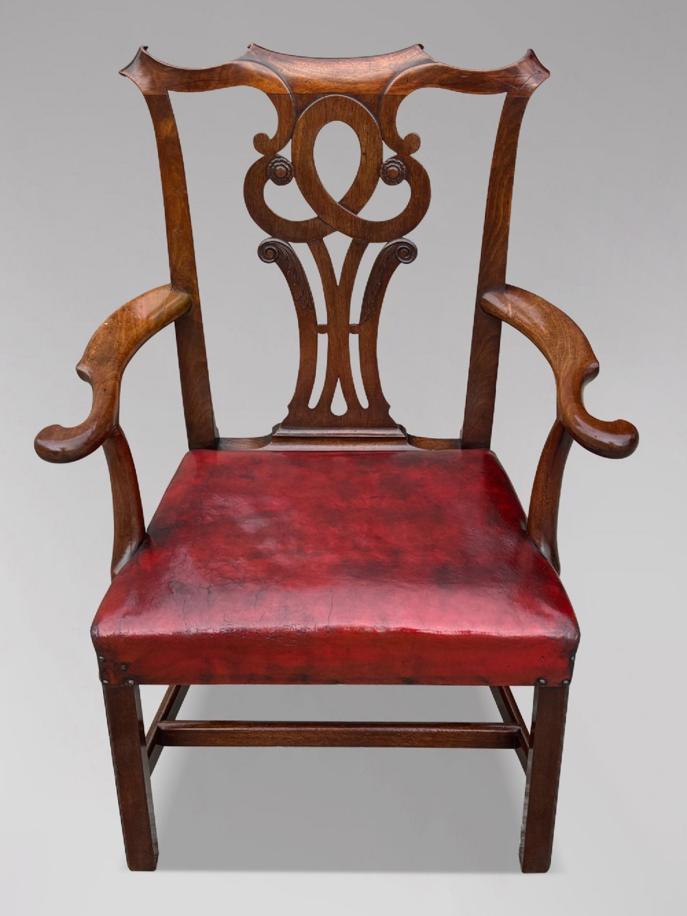 An 18th-century George III mahogany Chippendale armchair featuring a carved pierced splat back, curved arms, and a red leather upholstered seat. View II