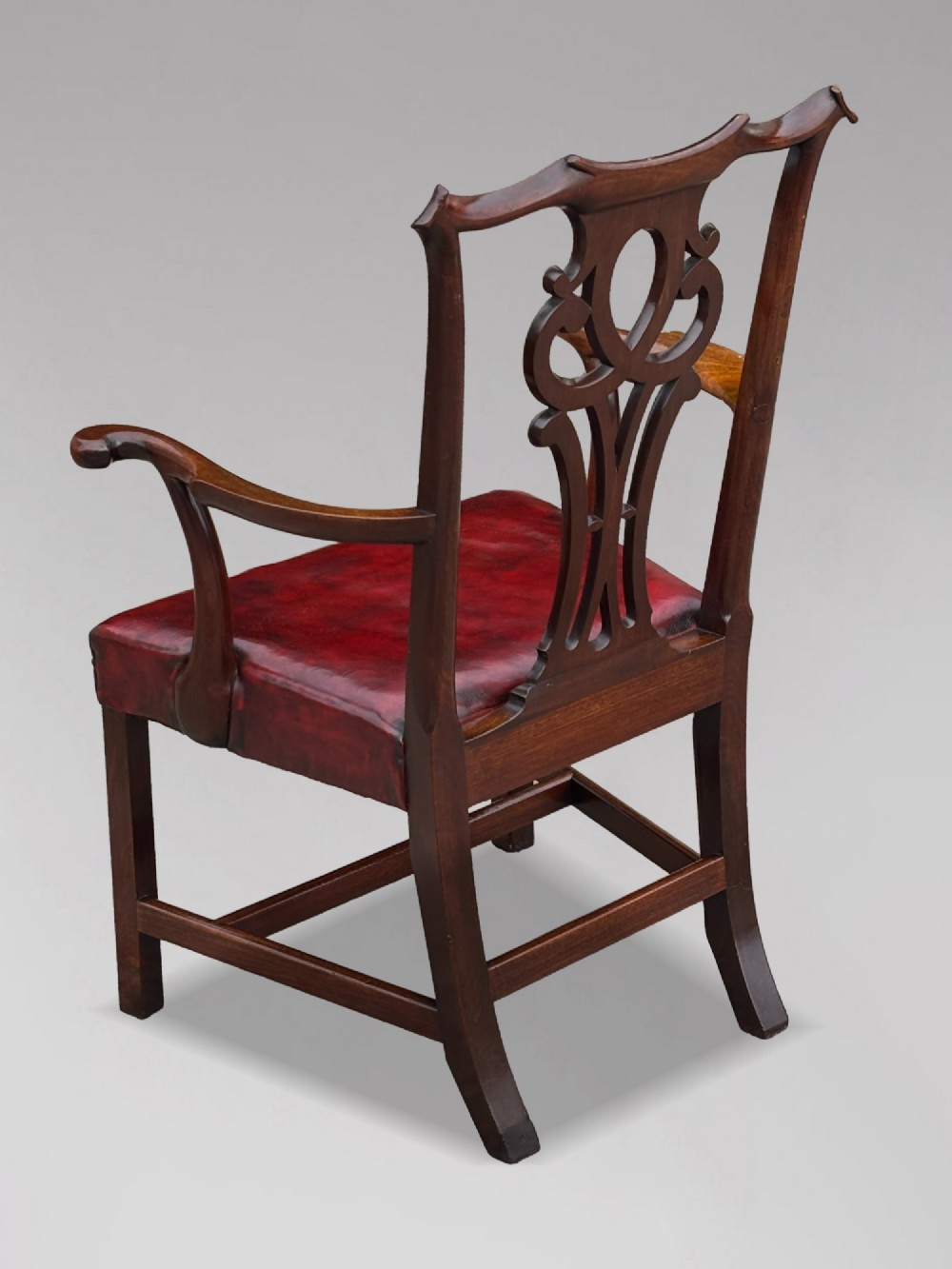 An 18th-century George III mahogany Chippendale armchair featuring a carved pierced splat back, curved arms, and a red leather upholstered seat. View III