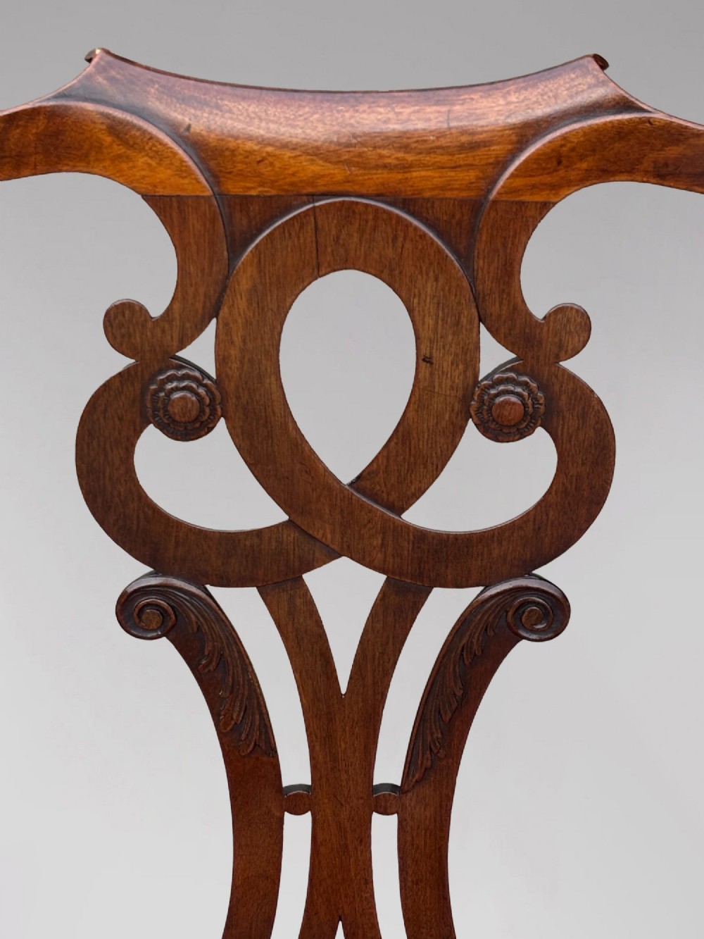 An 18th-century George III mahogany Chippendale armchair featuring a carved pierced splat back, curved arms, and a red leather upholstered seat. View VI