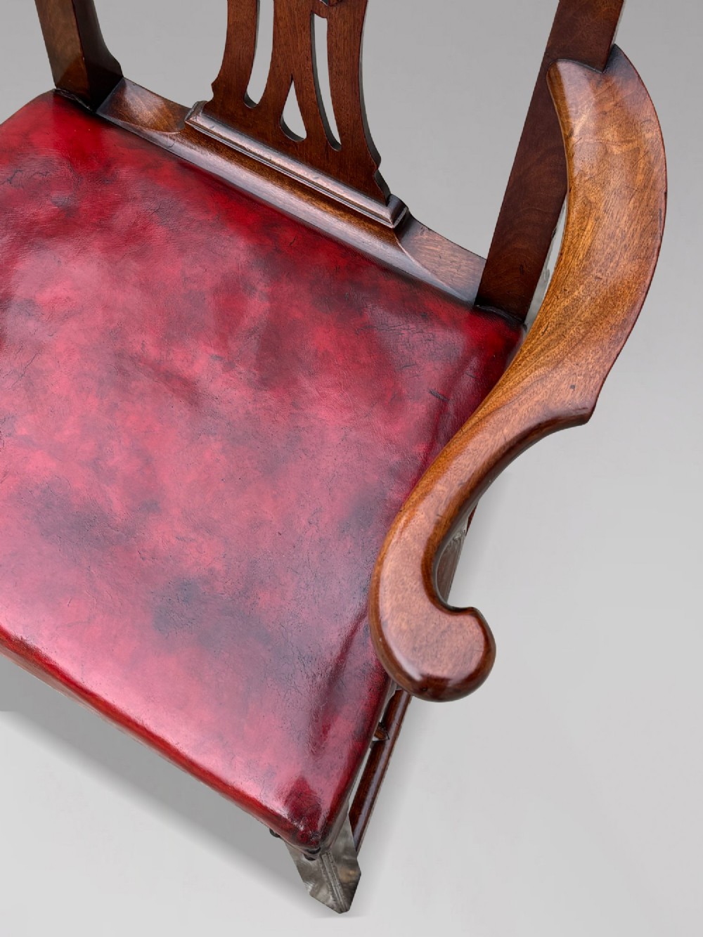 An 18th-century George III mahogany Chippendale armchair featuring a carved pierced splat back, curved arms, and a red leather upholstered seat. View VII