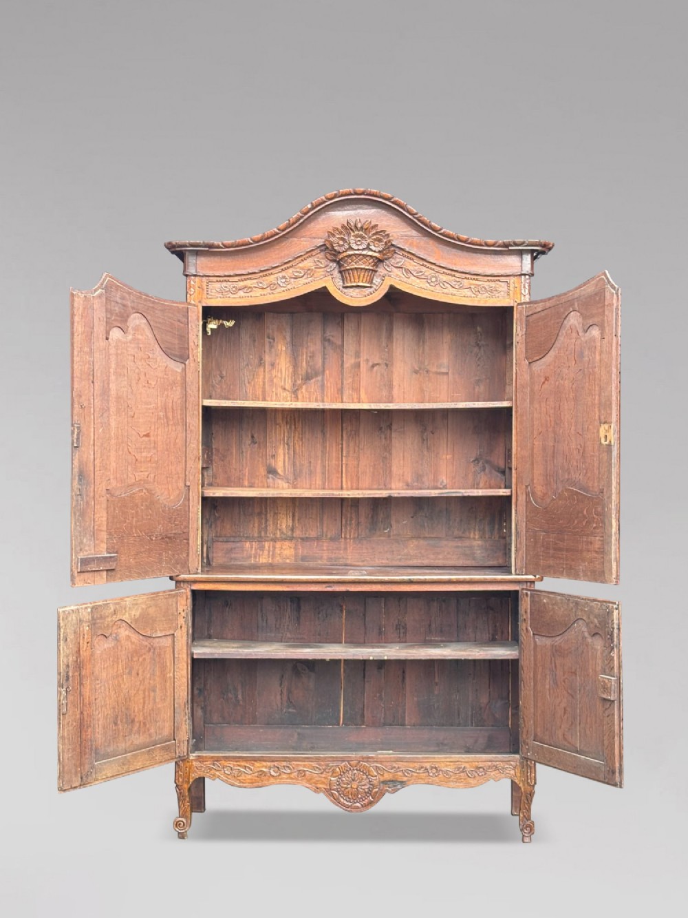An 18th-century French Louis XVI carved oak buffet deux corps featuring two upper panelled doors topped with a floral basket carving above a two-door base resting on short scrolled feet. View IV