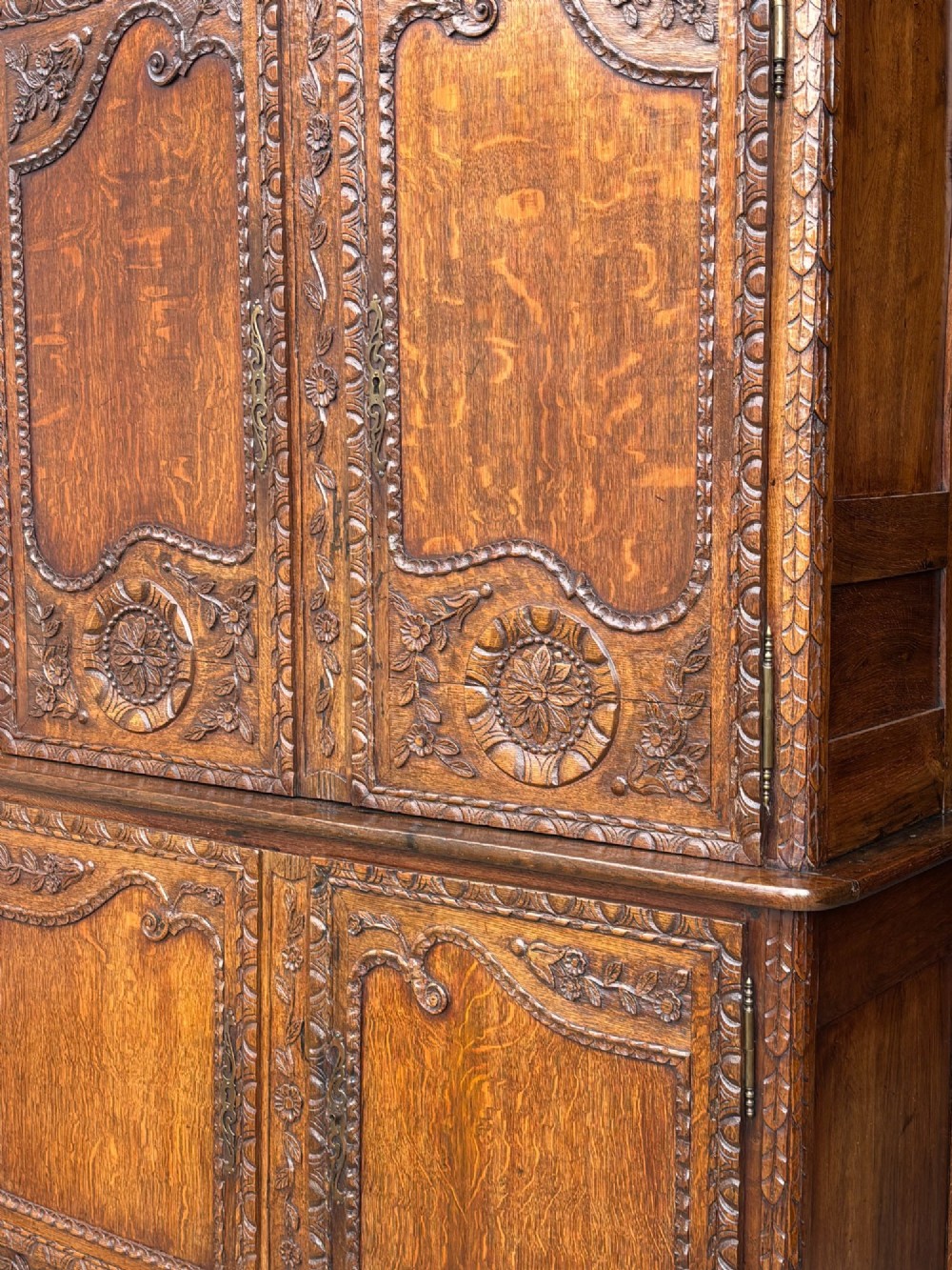An 18th-century French Louis XVI carved oak buffet deux corps featuring two upper panelled doors topped with a floral basket carving above a two-door base resting on short scrolled feet. View VI