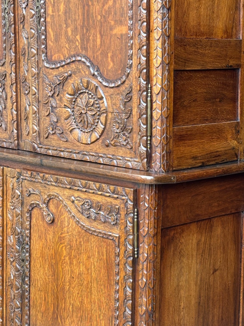 An 18th-century French Louis XVI carved oak buffet deux corps featuring two upper panelled doors topped with a floral basket carving above a two-door base resting on short scrolled feet. View VIII