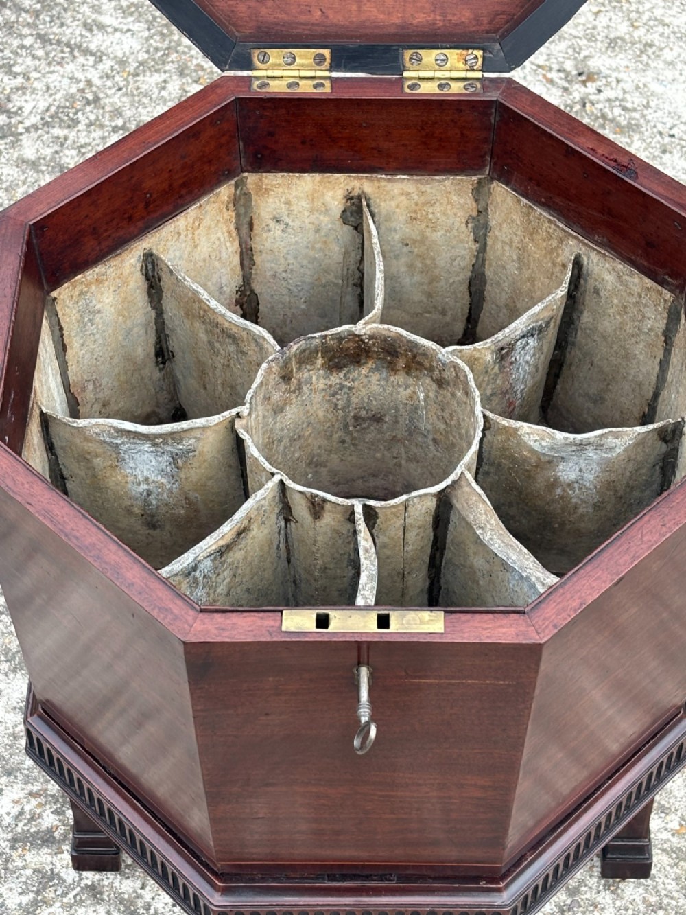 An eighteenth-century octagonal mahogany wine cooler featuring brass side handles, a keyhole detail, boxwood inlay, and fluted legs on castors. View V