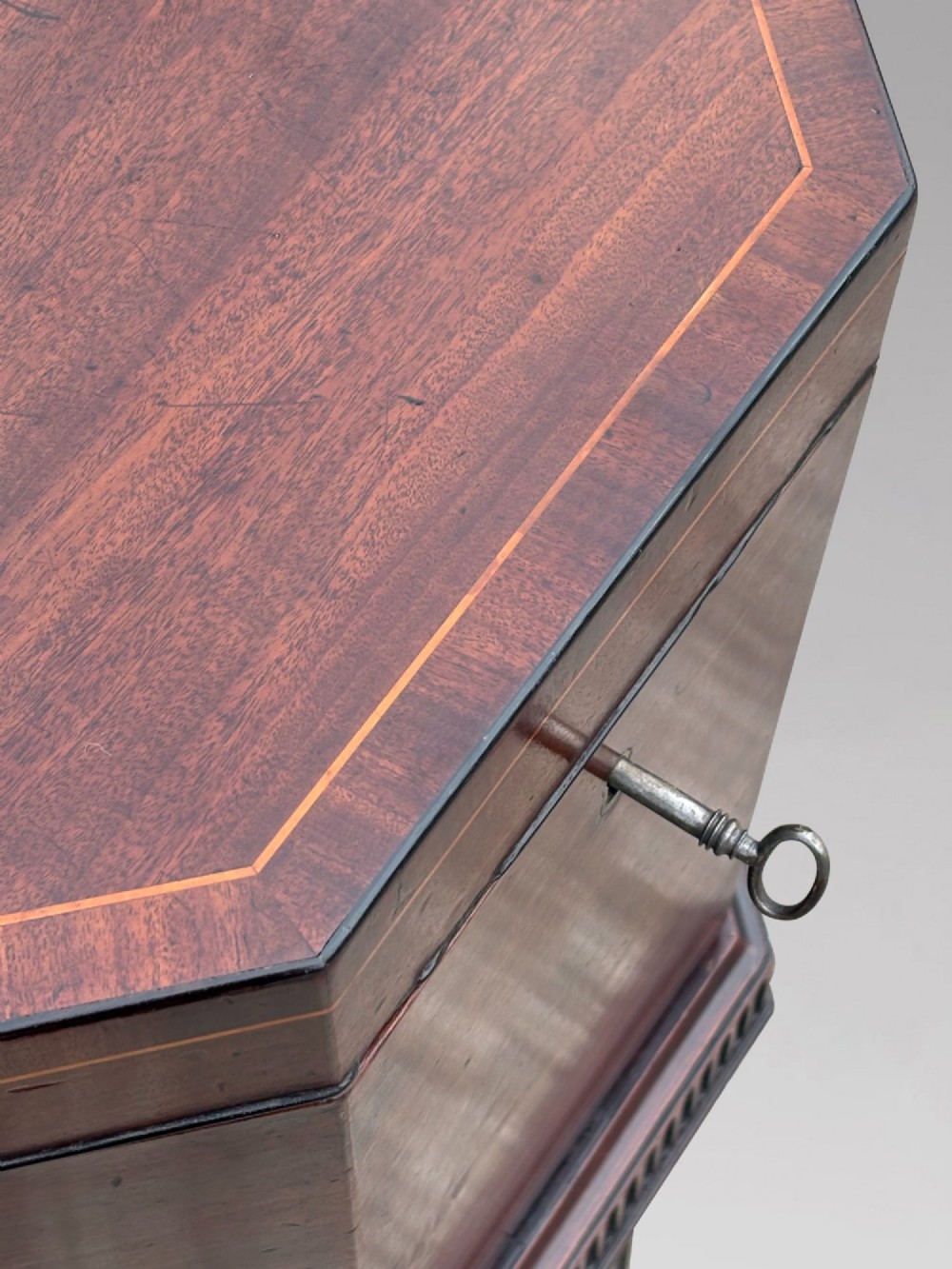 An eighteenth-century octagonal mahogany wine cooler featuring brass side handles, a keyhole detail, boxwood inlay, and fluted legs on castors. View VII
