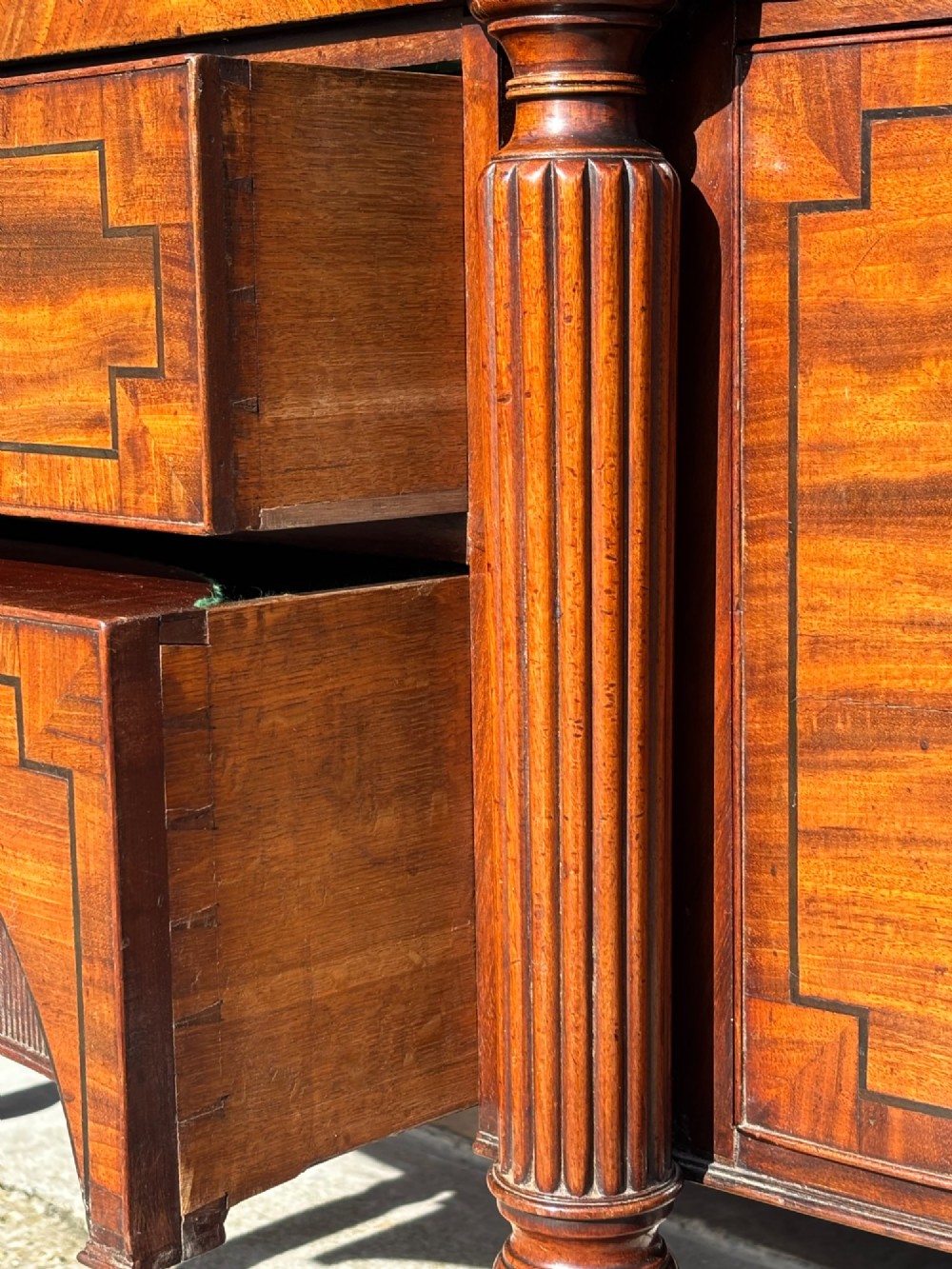 An antique 19th-century William IV mahogany sideboard featuring reeded fluted legs, line inlay, and a central drawer above an arched recess. View XI