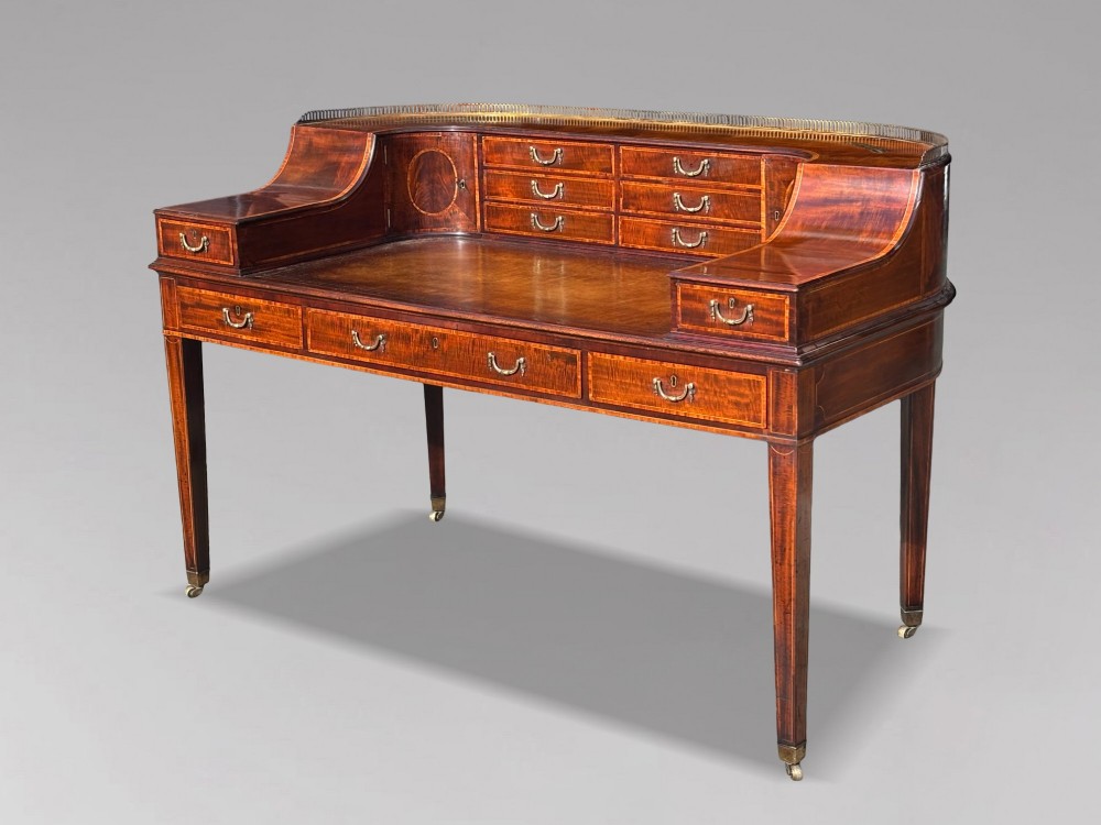 An 18th-century George III mahogany Carlton House desk with inlaid marquetry, a leather writing surface, small upper drawers, and tapered legs on brass castors.