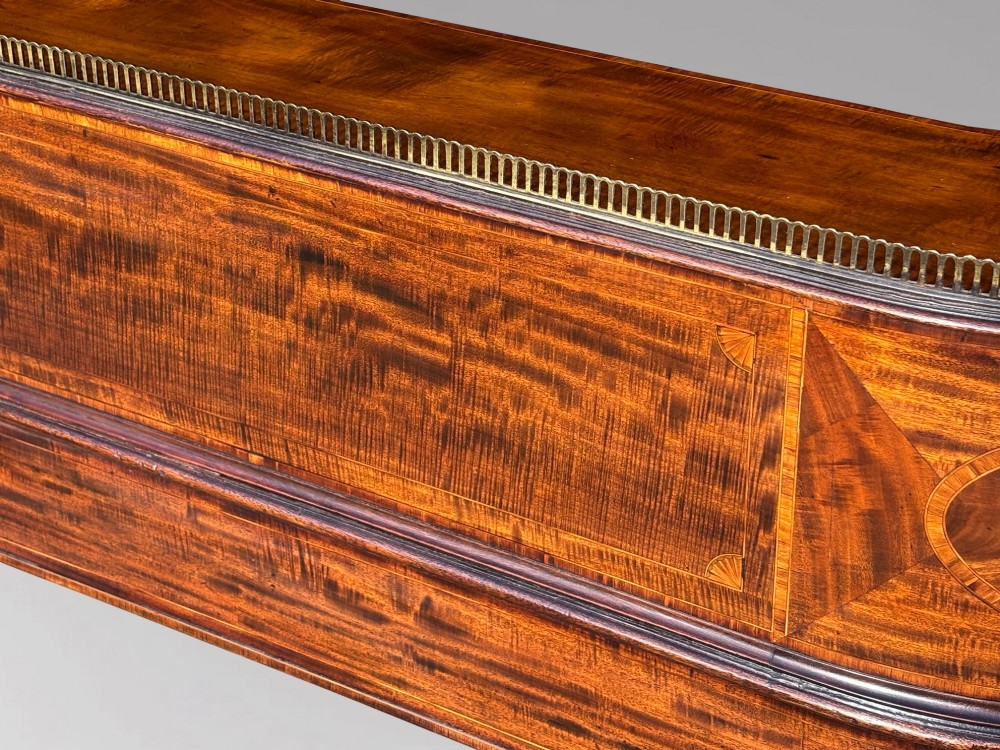 An 18th-century George III mahogany Carlton House desk with inlaid marquetry, a leather writing surface, small upper drawers, and tapered legs on brass castors. View XII