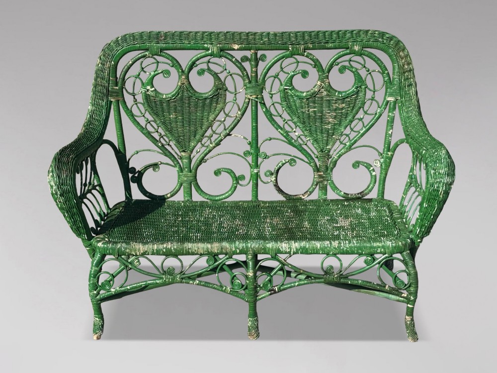 A French green painted wicker bench featuring two heart-shaped openwork back panels and curved armrests. View II