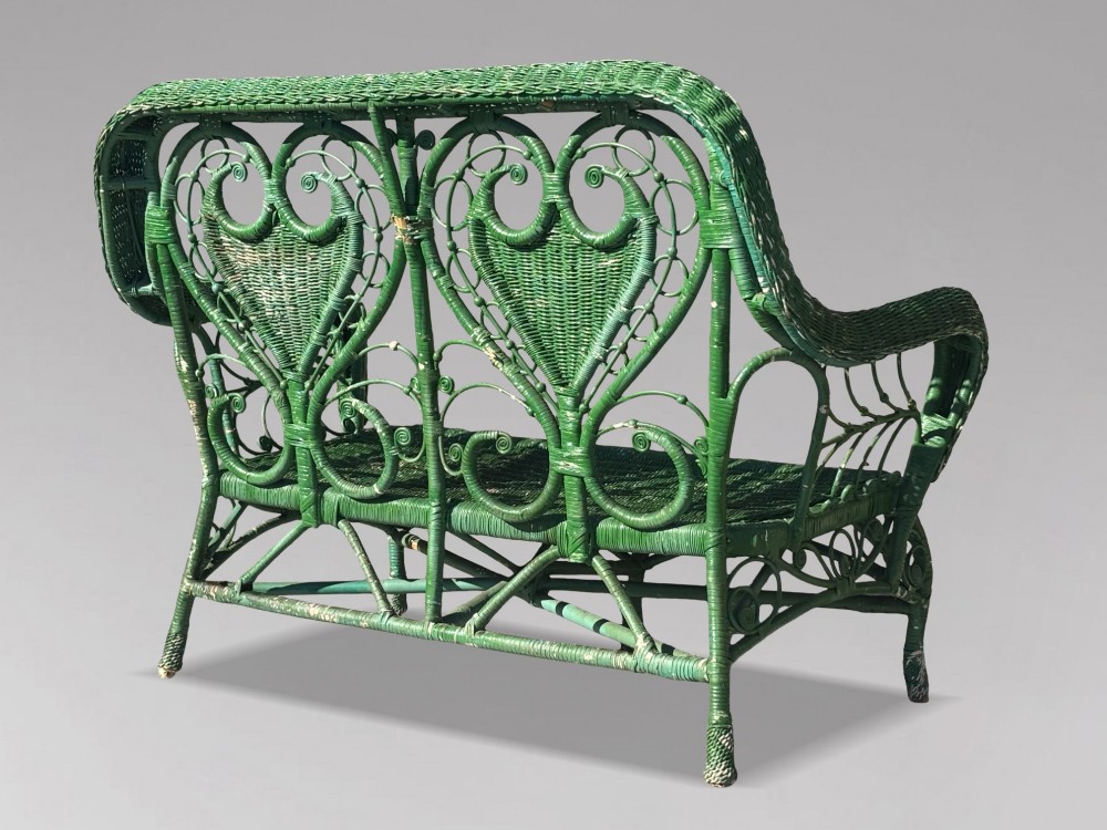 A French green painted wicker bench featuring two heart-shaped openwork back panels and curved armrests. View III