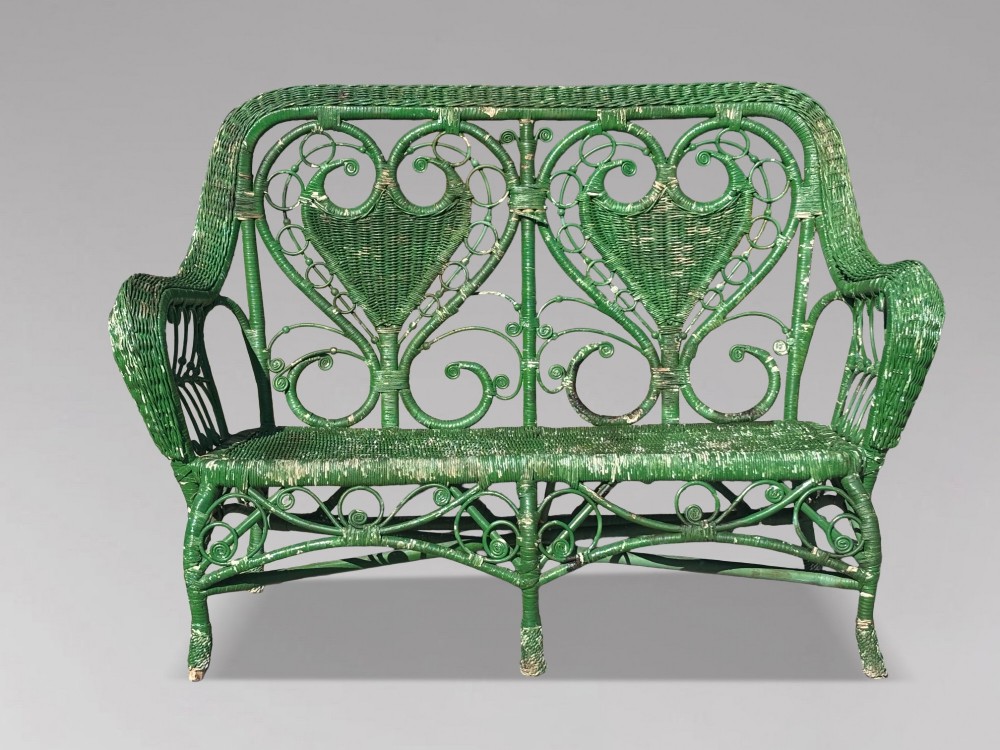A French green painted wicker bench featuring two heart-shaped openwork back panels and curved armrests. View VIII