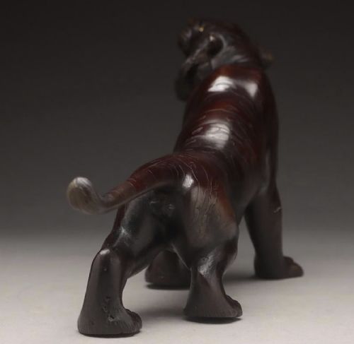 A dark patinated bronze sculpture depicting a snarling tiger in a low prowling stance with inset yellow crystal eyes. View V