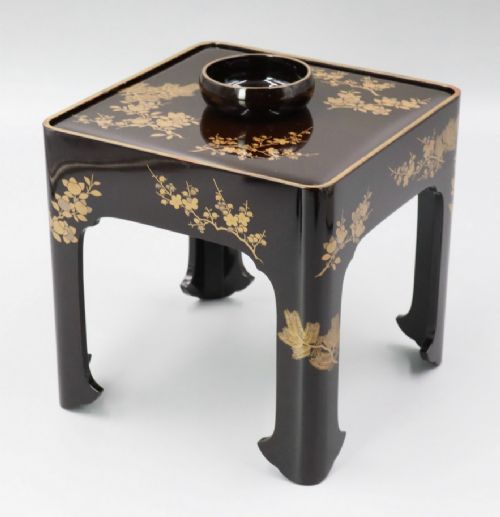 A square black lacquer miniature stand decorated with gold floral maki-e motifs, featuring a small matching black lacquer cup resting on top. View III