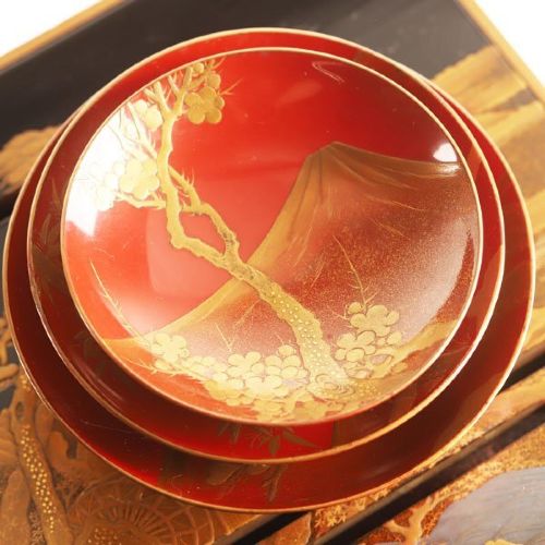 A Japanese black and gold lacquerware sake table featuring a raised stand, removable matching tray, and three red lacquer sakazuki cups adorned with painted gold motifs. View VII