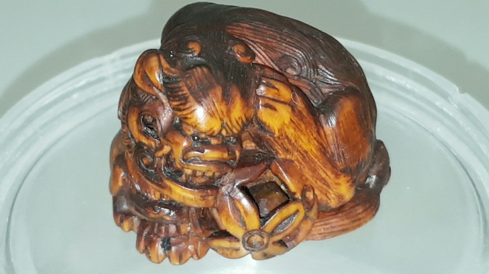 Japanese Edo (mid 19thC) Boxwood Netsuke of a Shishi Guarding a Sacred Ball, signed Masayoshi