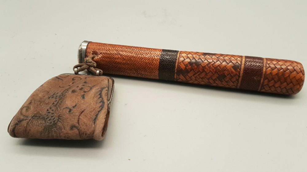 A Japanese woven bamboo pipe case with dark geometric weave bands paired with an attached pattern brocade purse. View II