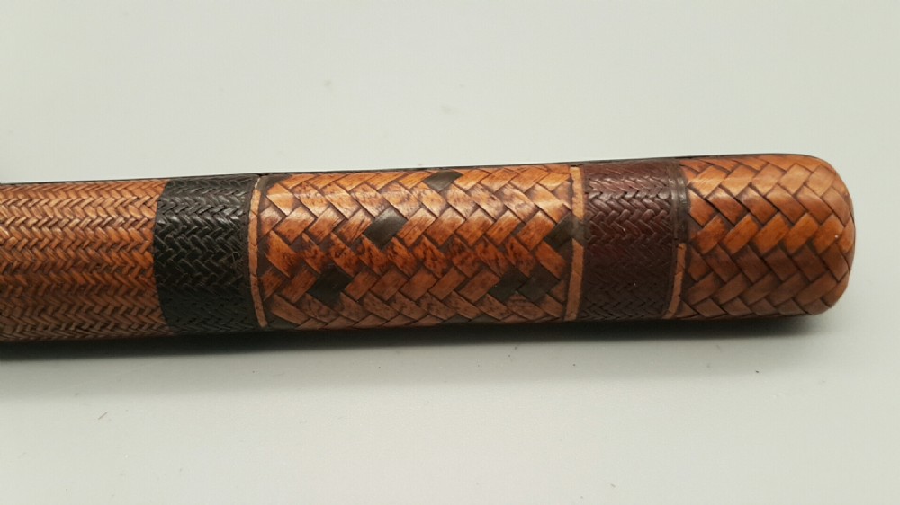 A Japanese woven bamboo pipe case with dark geometric weave bands paired with an attached pattern brocade purse. View III