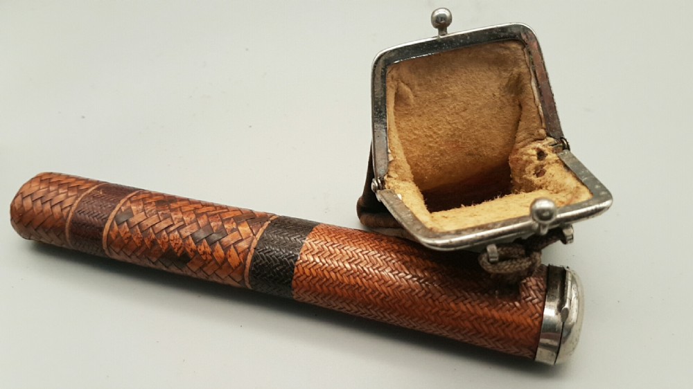 A Japanese woven bamboo pipe case with dark geometric weave bands paired with an attached pattern brocade purse. View VII