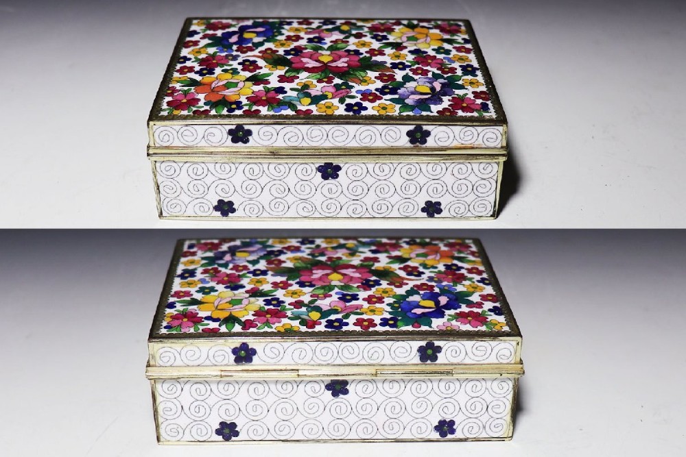A rectangular Japanese cloisonne enamel trinket box featuring vibrant floral motifs on top and a white ground with fine wire spirals around the sides. View II