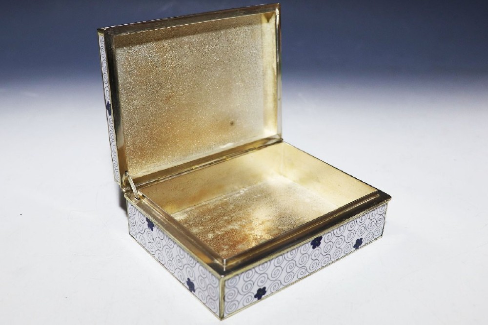 A rectangular Japanese cloisonne enamel trinket box featuring vibrant floral motifs on top and a white ground with fine wire spirals around the sides. View V