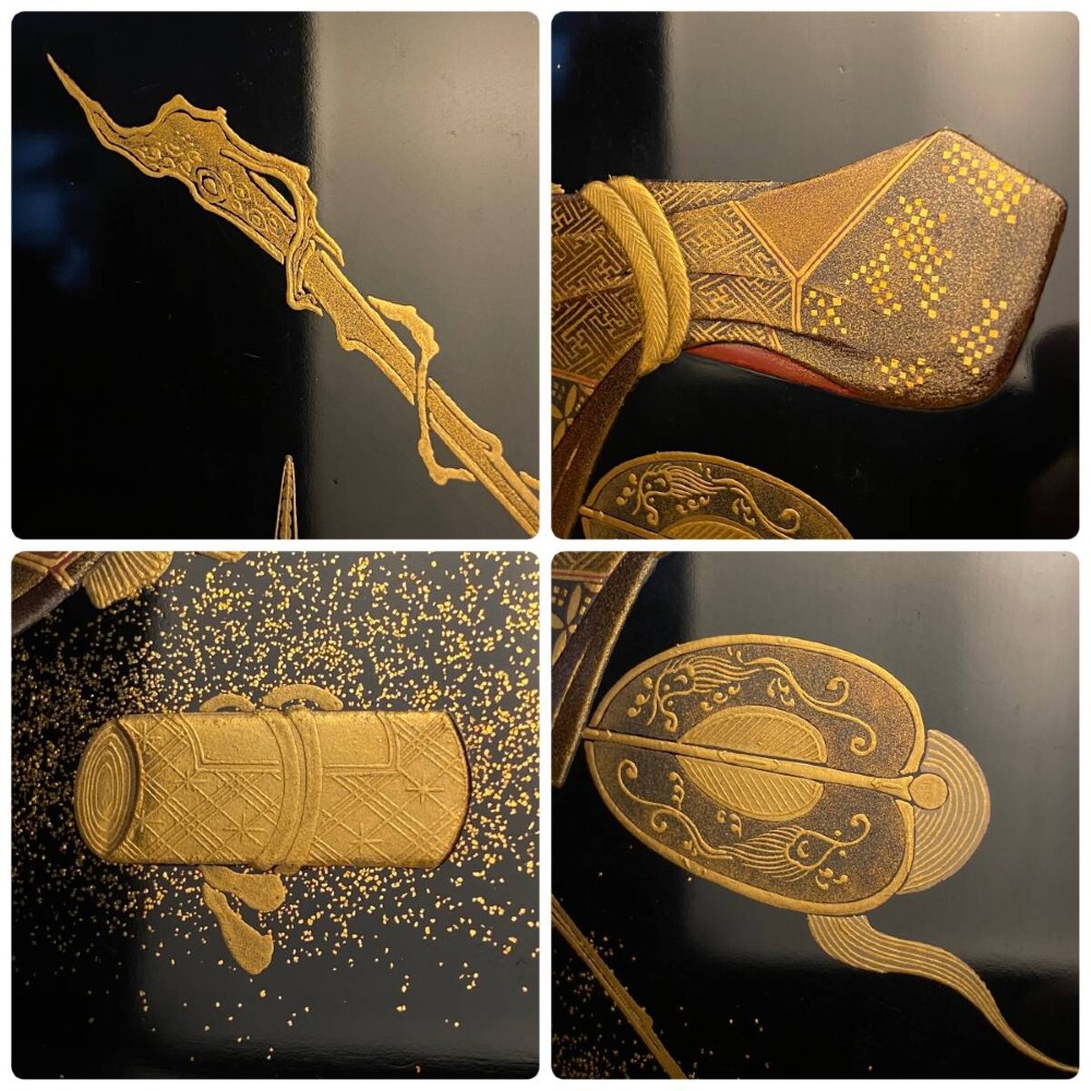 A large red lacquer Japanese sake cup decorated with gold maki-e motifs resting atop a dark brown wooden lacquer stand with a circular cutout. View VII