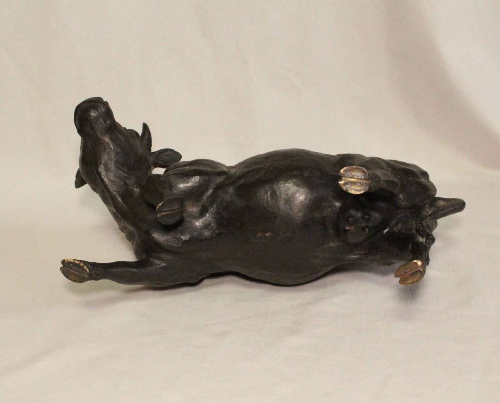 A late nineteenth-century Japanese cast bronze sculpture depicting a young boy seated atop a walking ox with a dark brown patina. View VIII