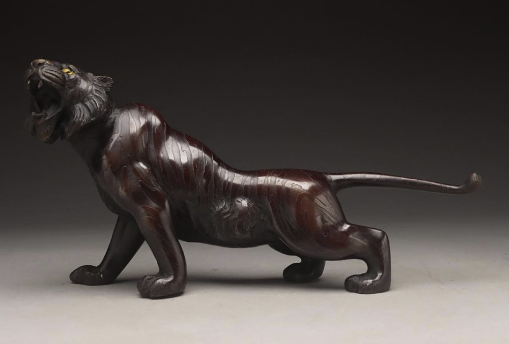 A dark patinated bronze sculpture depicting a snarling tiger in a low prowling stance with inset yellow crystal eyes. View III