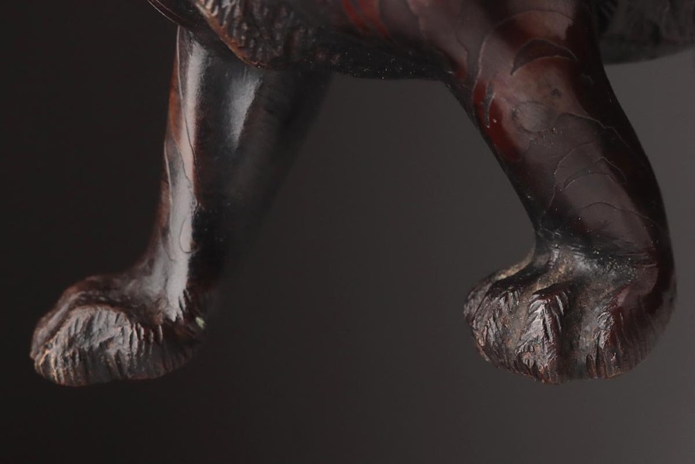 A dark patinated bronze sculpture depicting a snarling tiger in a low prowling stance with inset yellow crystal eyes. View XII