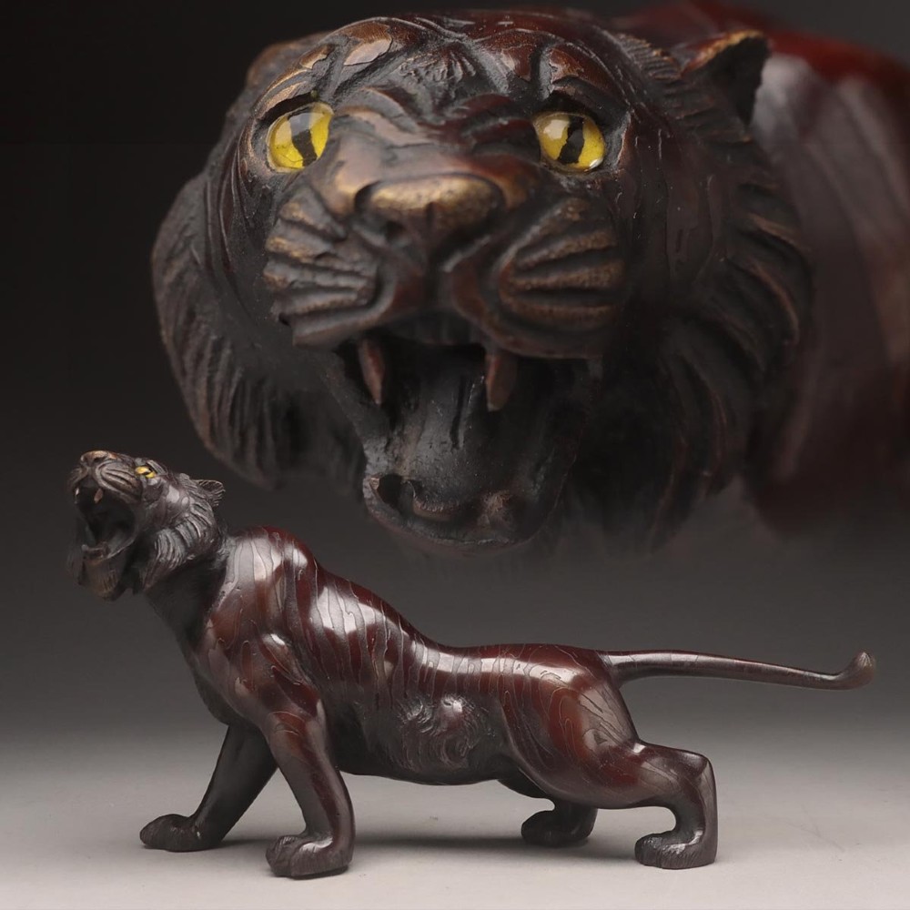 A dark patinated bronze sculpture depicting a snarling tiger in a low prowling stance with inset yellow crystal eyes. View XIV