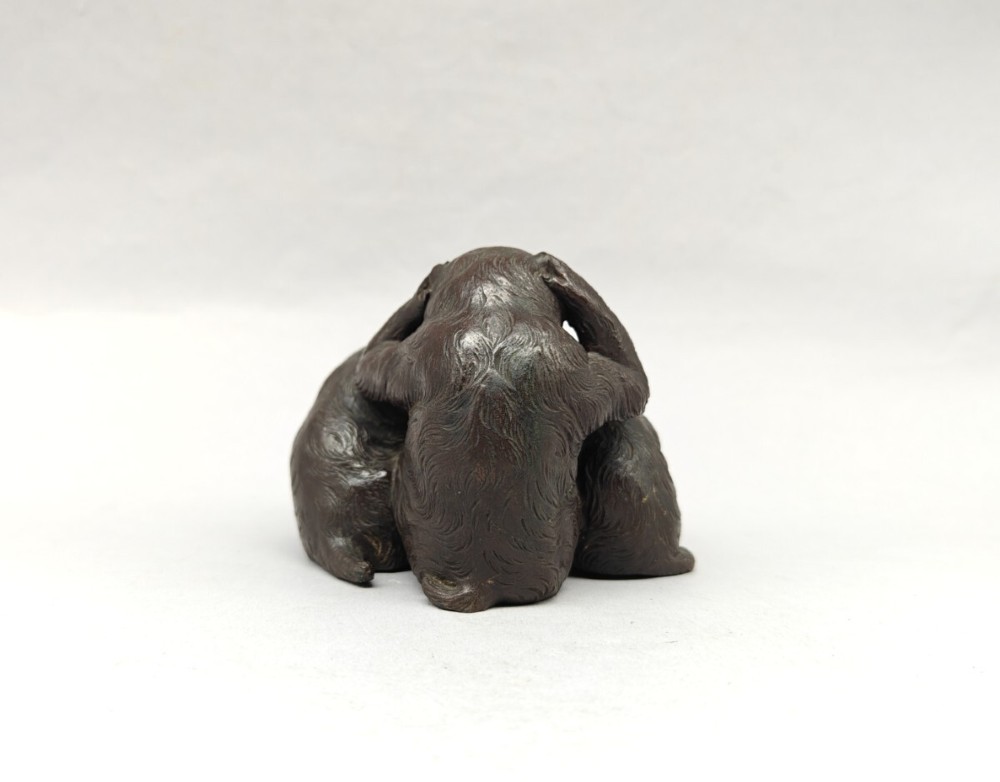 A patinated dark bronze sculpture depicting three monkeys seated together representing the motif of see no evil, hear no evil, and speak no evil. View IV