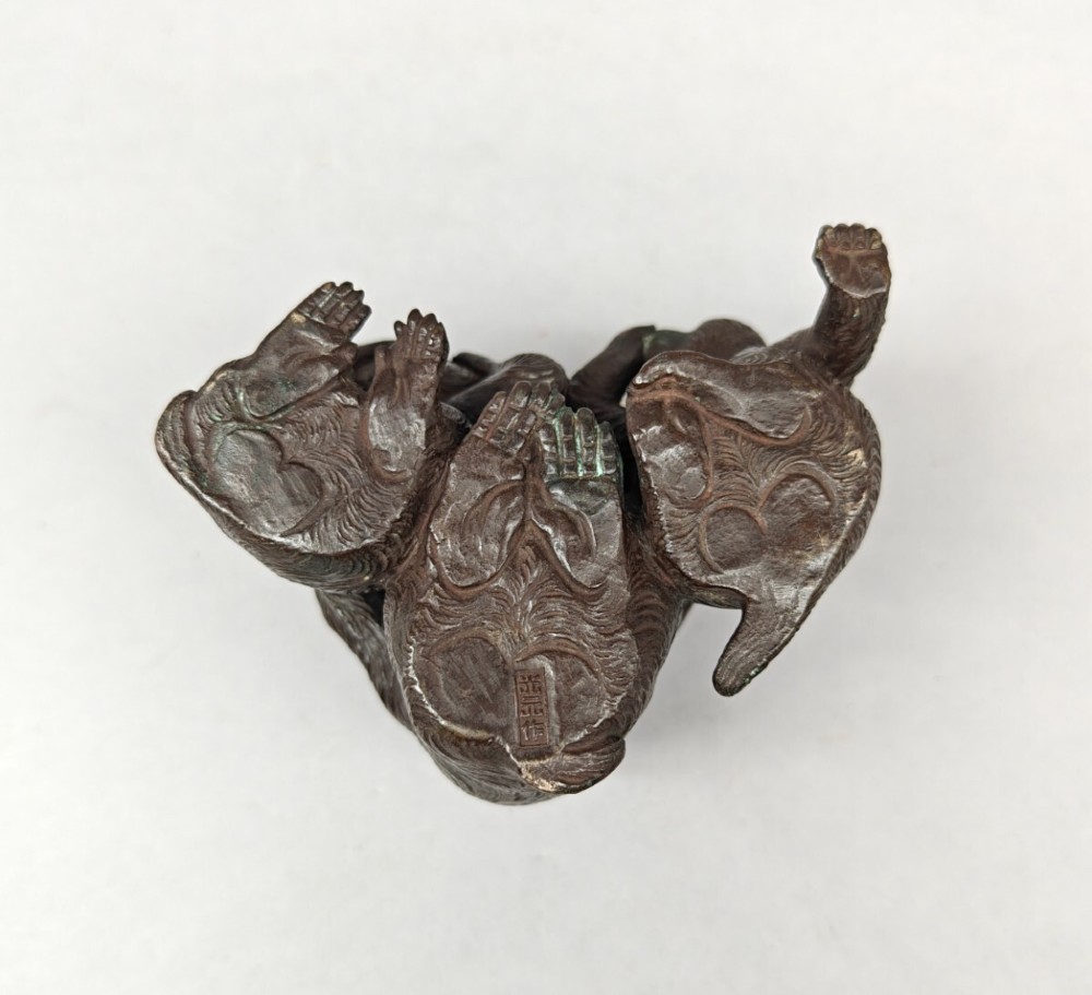 A patinated dark bronze sculpture depicting three monkeys seated together representing the motif of see no evil, hear no evil, and speak no evil. View IX