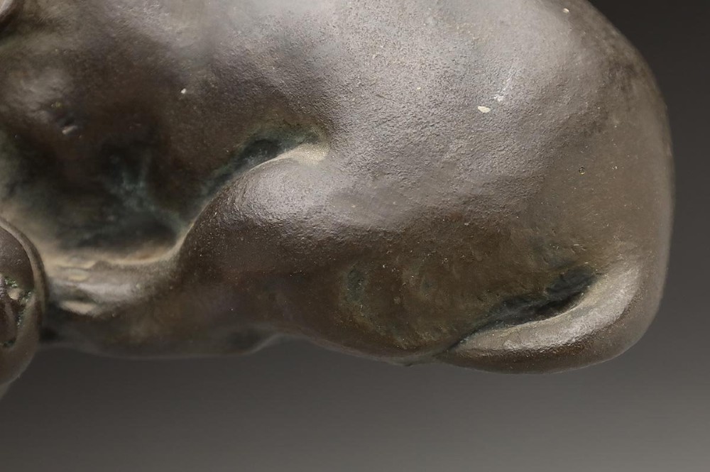 A dark patinated bronze sculpture depicting three sleeping puppies curled closely together. View VIII