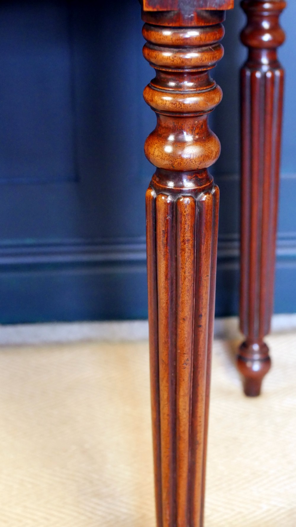 A nineteenth-century William IV mahogany fold-over tea table featuring reeded turned legs and a polished timber surface. View V