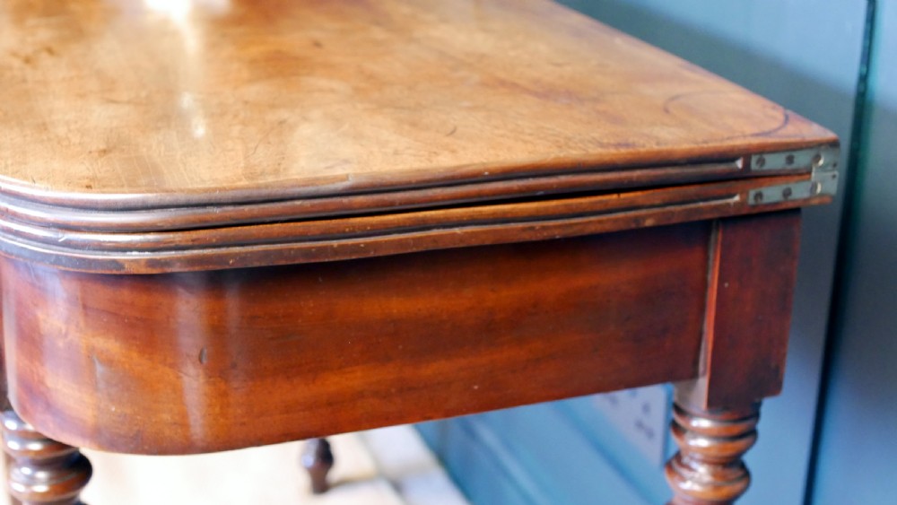 A nineteenth-century William IV mahogany fold-over tea table featuring reeded turned legs and a polished timber surface. View VII
