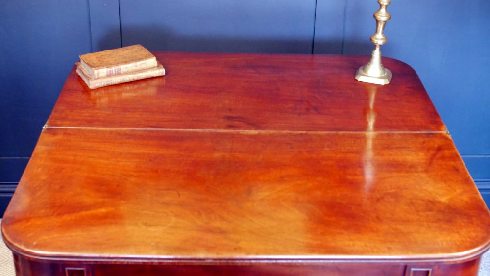A nineteenth-century William IV mahogany fold-over tea table featuring reeded turned legs and a polished timber surface. View XI