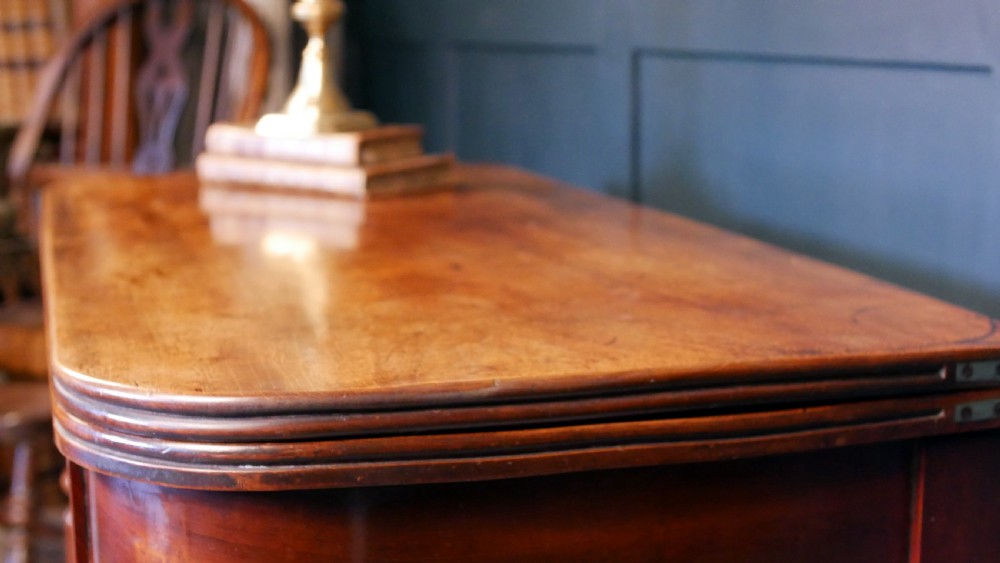 A nineteenth-century William IV mahogany fold-over tea table featuring reeded turned legs and a polished timber surface. View XIII