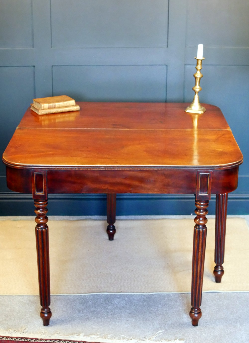 A nineteenth-century William IV mahogany fold-over tea table featuring reeded turned legs and a polished timber surface. View XIV