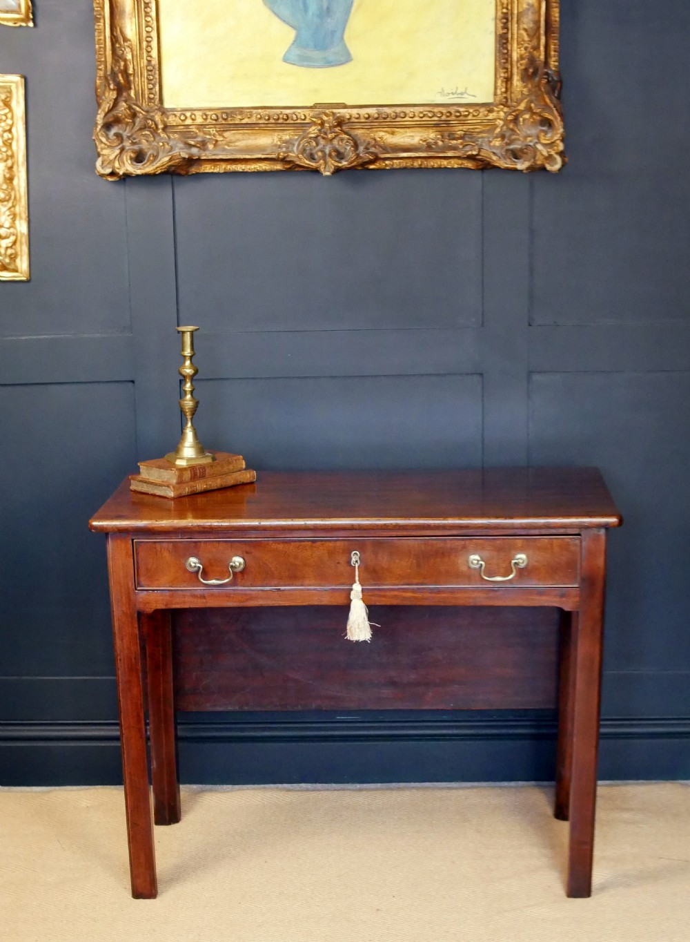 A George IV mahogany console table with a single frieze drawer, brass swan-neck handles, key tassel, and straight square legs. View III