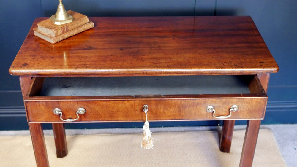A George IV mahogany console table with a single frieze drawer, brass swan-neck handles, key tassel, and straight square legs. View V