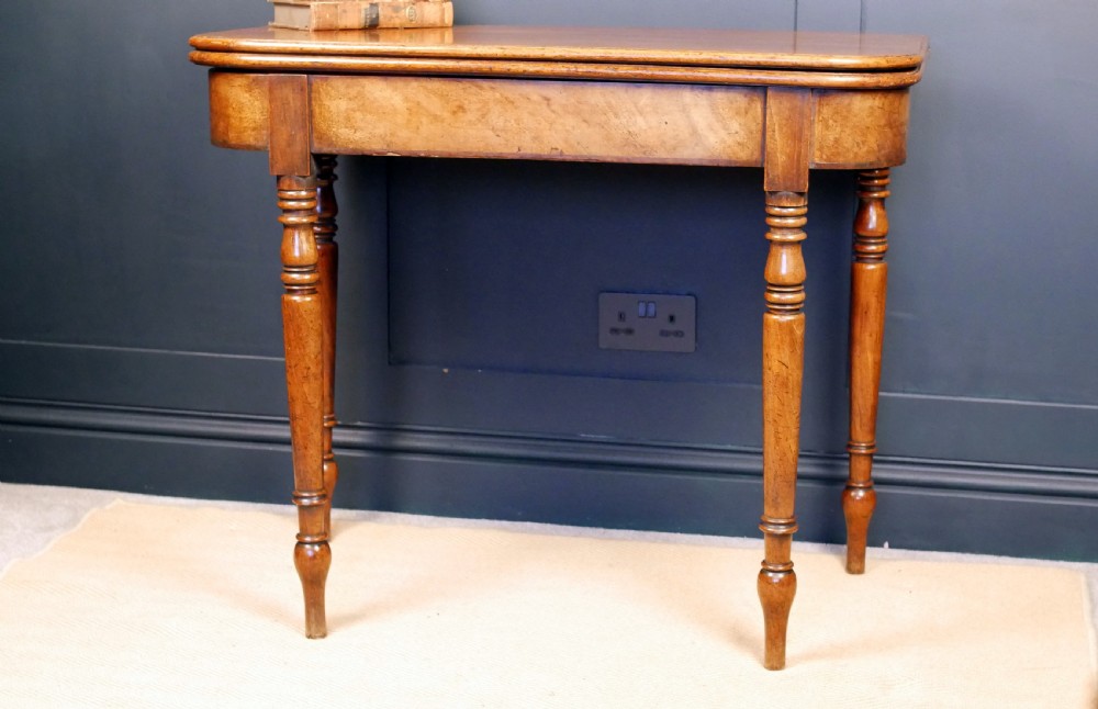 A Regency mahogany fold-over tea table featuring a rectangular hinged top with rounded corners, a deep frieze, and turned tapered legs. View II