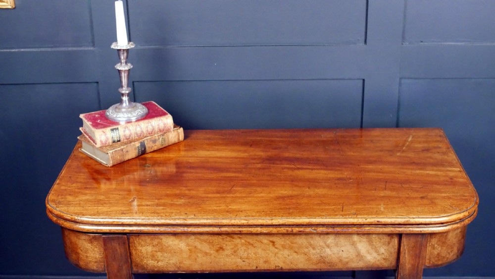 A Regency mahogany fold-over tea table featuring a rectangular hinged top with rounded corners, a deep frieze, and turned tapered legs. View III