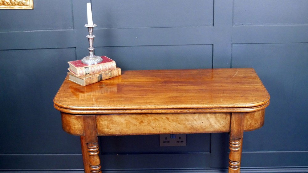 A Regency mahogany fold-over tea table featuring a rectangular hinged top with rounded corners, a deep frieze, and turned tapered legs. View IV
