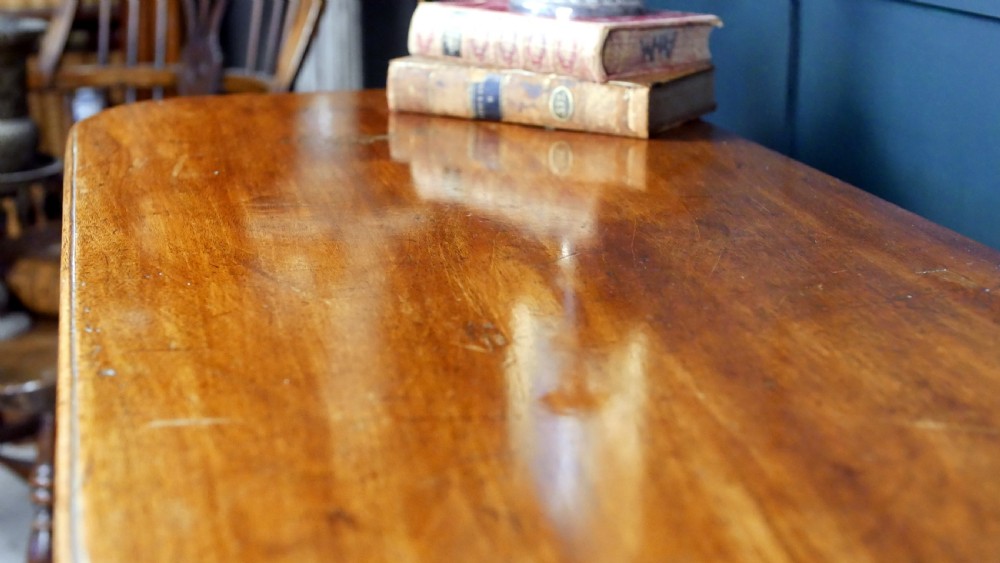 A Regency mahogany fold-over tea table featuring a rectangular hinged top with rounded corners, a deep frieze, and turned tapered legs. View VIII