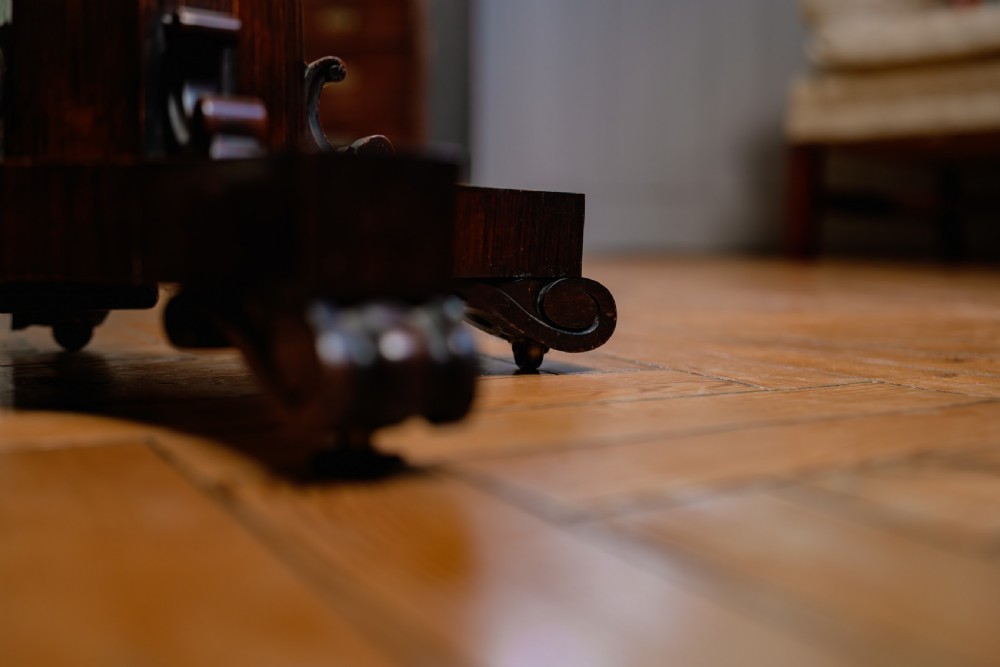 A Victorian rosewood teapoy featuring a rectangular hinged box top with a keyhole, supported by a tapered pedestal column on a four-pointed plinth base with scroll feet. View II