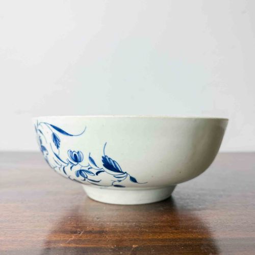 fig 2. An 18th-century circular soft-paste porcelain bowl featuring hand-painted cobalt blue floral motifs on a white background.