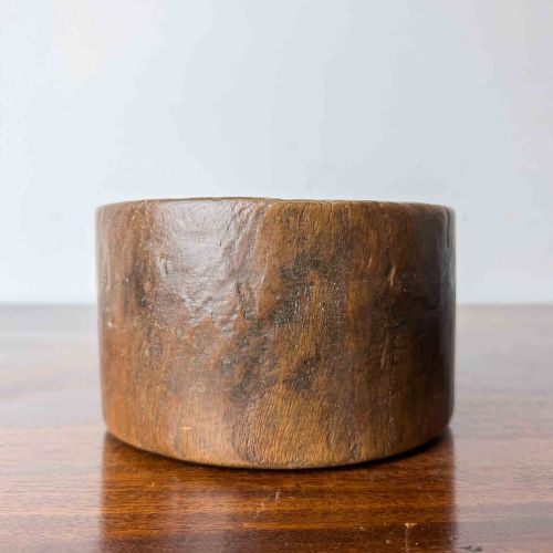 fig 1. A round hand-carved antique wooden bowl with thick walls and a patinated brown timber surface.