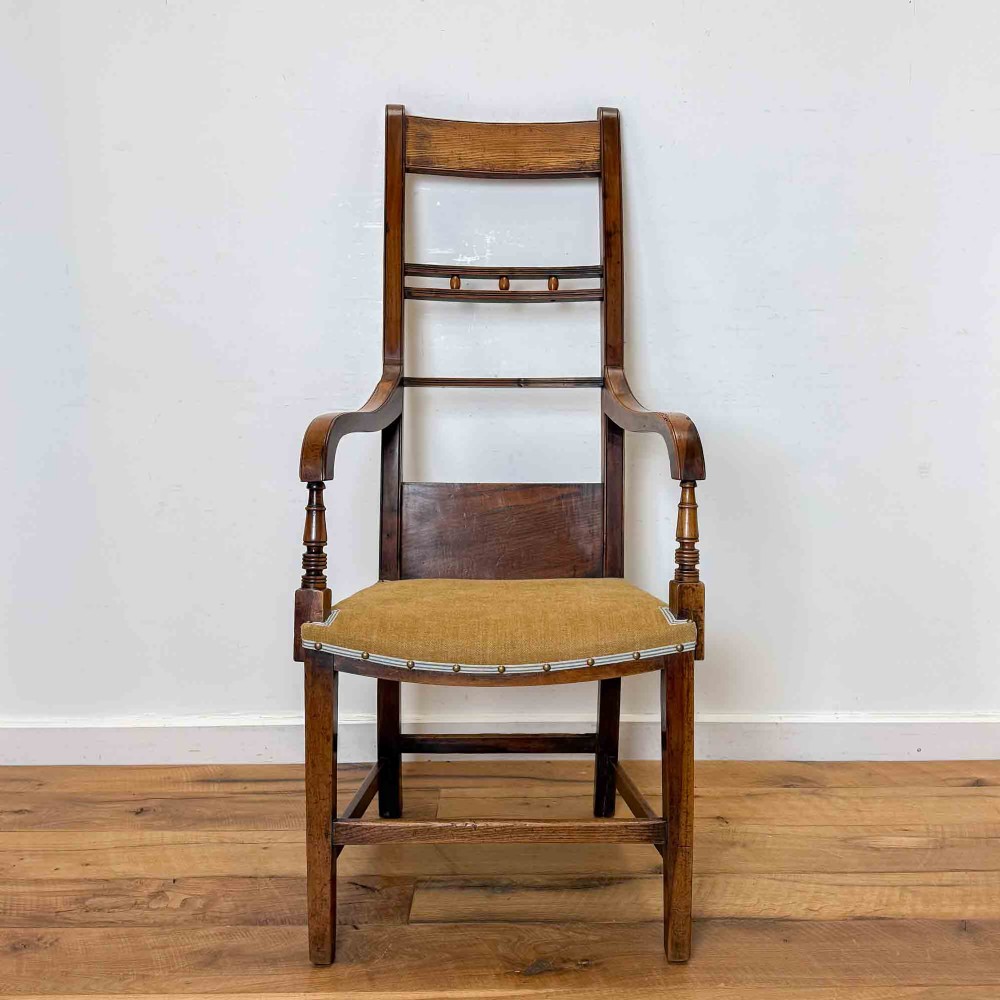 A Regency period high back open armchair crafted from fruitwood and elm with turned arm supports and a textured ochre upholstered seat. View III