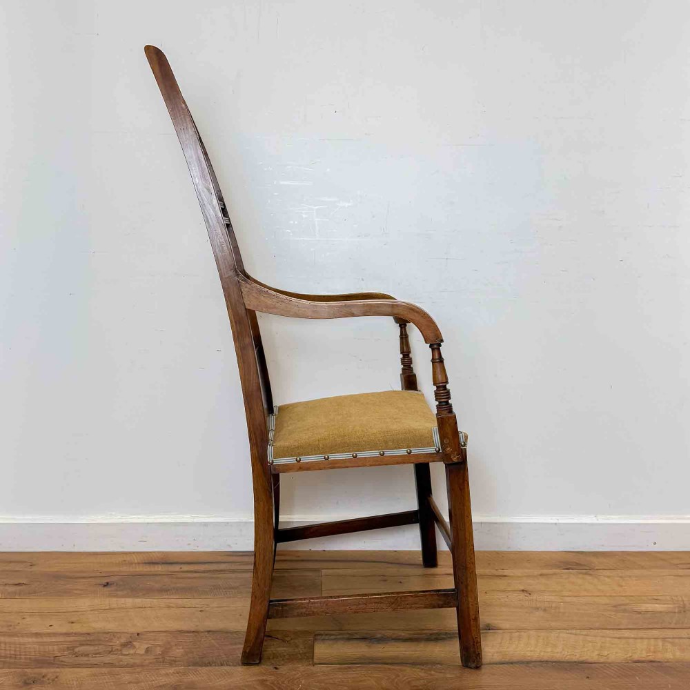 A Regency period high back open armchair crafted from fruitwood and elm with turned arm supports and a textured ochre upholstered seat. View IV
