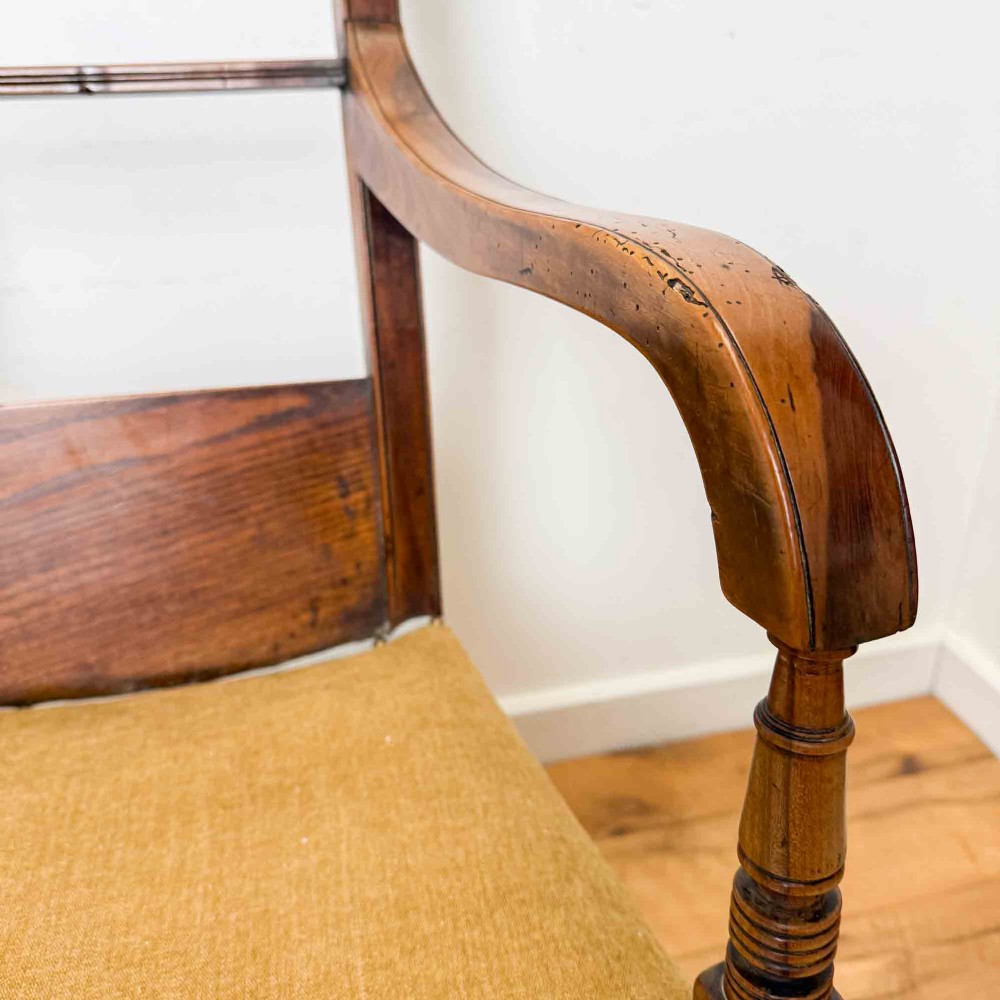 A Regency period high back open armchair crafted from fruitwood and elm with turned arm supports and a textured ochre upholstered seat. View XI