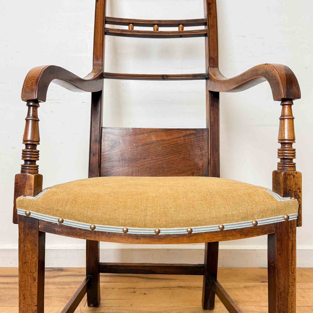 A Regency period high back open armchair crafted from fruitwood and elm with turned arm supports and a textured ochre upholstered seat. View XII